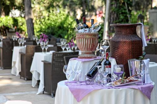 a table with wine glasses and a vase on it at Rodos Park in Rhodes Town