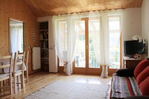 a living room with large windows with white curtains at Apartmentshaus Dual -1 in Lake Pressegg