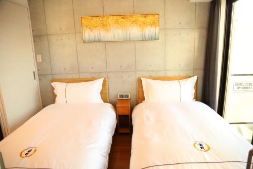two beds sitting next to each other in a room at Yoshitsuki kaku - Yoshitsuki Apart Hotel in Tokyo
