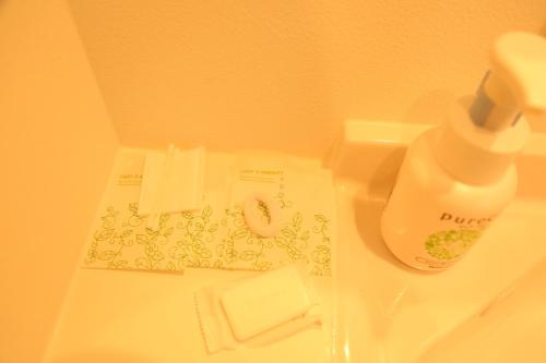 a bottle of water sitting on top of a sink at Yoshitsuki kaku - Yoshitsuki Apart Hotel in Tokyo