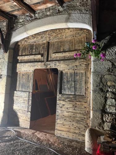 a wooden door in the side of a building with flowers at Chambres d'hôtes des Deux Lacs in Ceyzérieu