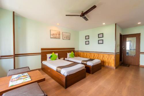 a bedroom with two beds and a table at Opiam B&B A Business Hotel in Kolkata