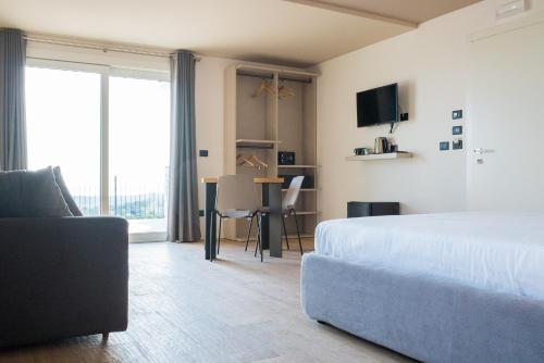 1 dormitorio con 1 cama y 1 mesa con silla en Encanto Agriturismo & Private SPA, en Visogliano