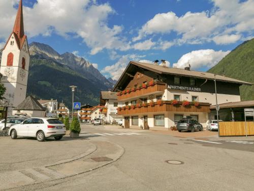 a small town with a church and a street with cars at Apartments Rainer in Anterselva di Mezzo