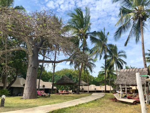 a resort with palm trees and a path at Eleven Pearl Boutique Hotel & Spa in Diani Beach
