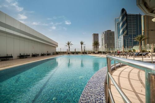 ein Schwimmbad in der Mitte eines Gebäudes in der Unterkunft Novotel Fujairah in Fudschaira