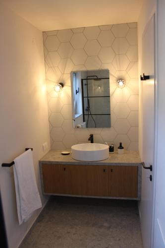 een badkamer met een wastafel en een spiegel bij Fourfouras Cottage in Fourfourás