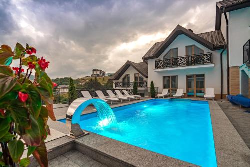 a swimming pool in front of a house at Chalet Fomich in Bukovel