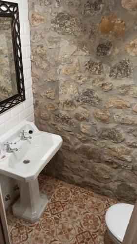 a bathroom with a sink and a stone wall at Abuela Eulalia in Maraña