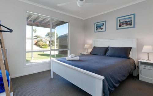 a bedroom with a bed and a large window at Rocks Beach House Victor Harbor in Hayborough