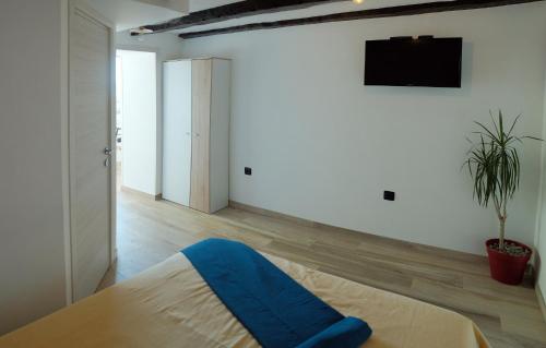 een slaapkamer met een bed en een tv aan de muur bij Apartmani Donata in Rijeka