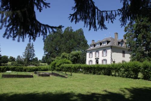 a large white house sitting on top of a field at HOSTELLERIE LA BRUYERE in Chalvignac