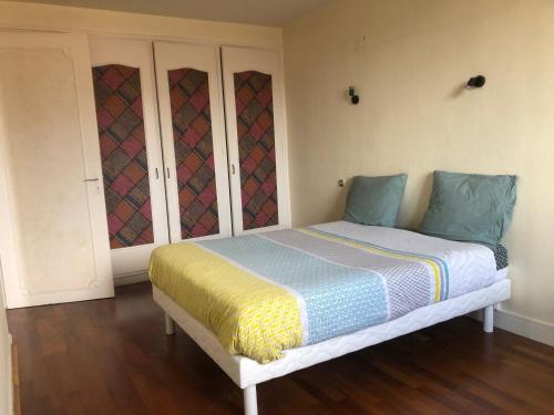 een slaapkamer met een bed met blauwe en gele lakens bij L’ÉMERAUDE 2 in Châlons-en-Champagne