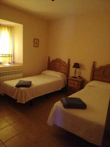 a hotel room with two beds and a window at Casa Rural el Picozo in Horcajo de la Ribera