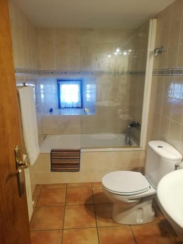 a bathroom with a toilet and a tub and a sink at Casa Rural del Chopo in La Aliseda de Tormes