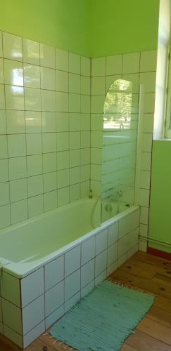 une salle de bain avec une baignoire et un miroir dans l'établissement Maison Bois Renard, à Saint-Laurent-Nouan