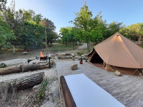 a large tent with a fire in a field at Agriturismo e Glamping Serraiola Alta in Frassine