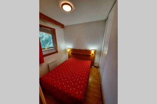 un sofá rojo en una habitación pequeña con ventana en Appartement en plein coeur du Queyras - Les Granges d'Arvieux en Arvieux
