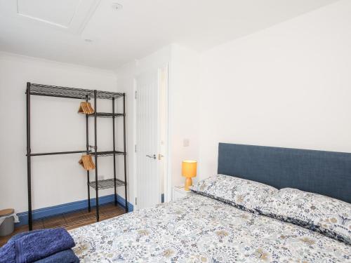 a bedroom with a bed with a blue head board at Ty Coets Coach House in Caernarfon