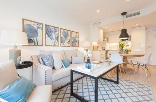 Una sala de estar con un sofá blanco y una mesa. en Premium Apartment in Benalbeach, Benalmadena, en Benalmádena