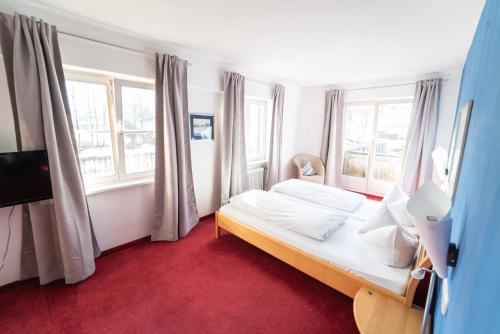 a bedroom with a bed and two windows at Ihre Pension in Amerang in Amerang