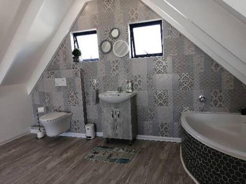 a bathroom with a sink and a tub and a toilet at De Loft in Jacobs Bay