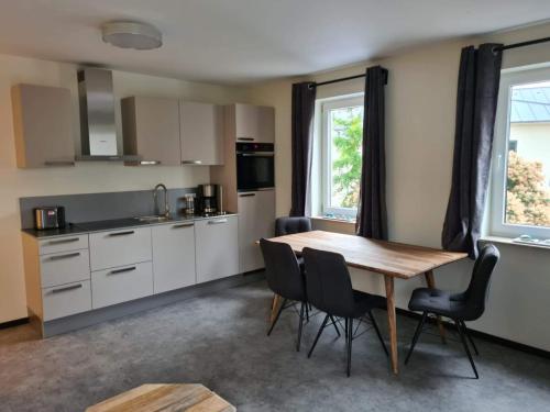 a kitchen with a wooden table and chairs in a room at Villa Weisse Düne in Göhren