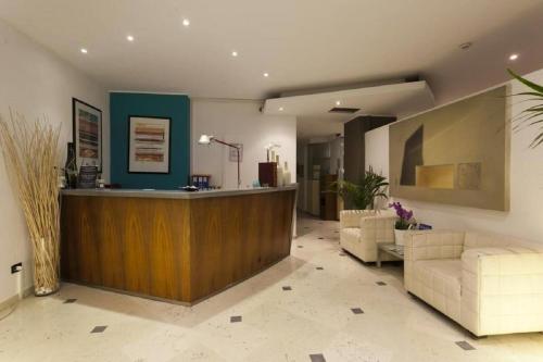 a lobby with a reception desk and couches at Hotel Centrale in Lido di Jesolo