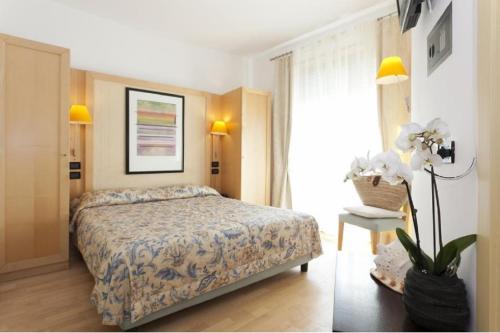 una camera d'albergo con letto e finestra di Hotel Centrale a Lido di Jesolo