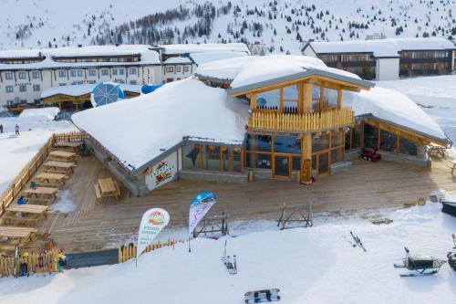 a large wooden building with snow on top of it at Sporting Hotel in Passo del Tonale