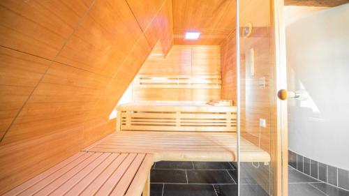 a sauna with a wooden floor and wooden stairs at Romantik Hotel Walhalla in Osnabrück
