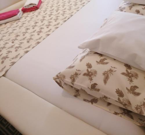 a bed with two pillows on top of it at Apartman Centar in Kruševac