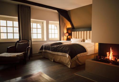Habitación de hotel con cama y chimenea en Romantik Hotel Walhalla en Osnabrück