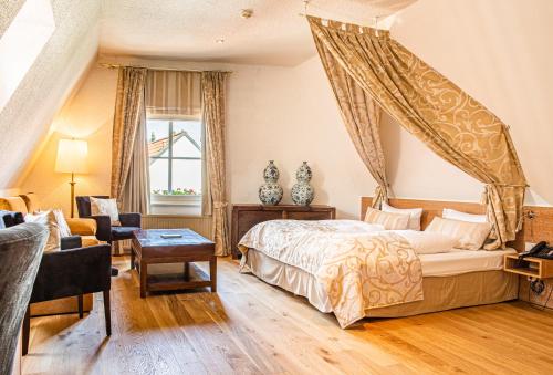 a bedroom with a canopy bed and a living room at Romantik Hotel Walhalla in Osnabrück