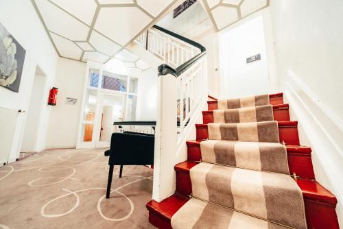 a staircase in a house with a piano at Romantik Hotel Walhalla in Osnabrück