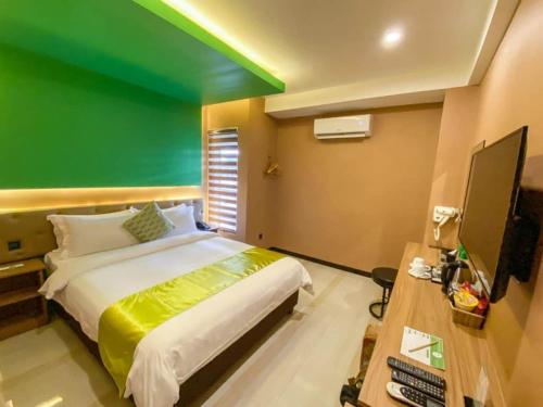 a bedroom with a large bed and a green wall at Vivien's Hotel in Mactan