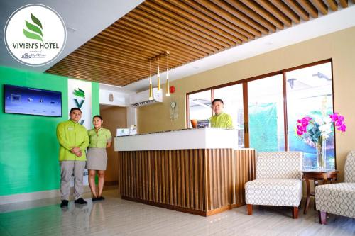 tres personas de pie en un mostrador en el vestíbulo del hospital en Vivien's Hotel en Isla de Mactán