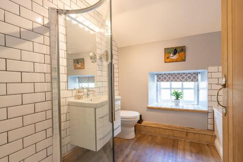 AlstonfieldにあるBankside Cottageのバスルーム(洗面台、トイレ付)、窓が備わります。