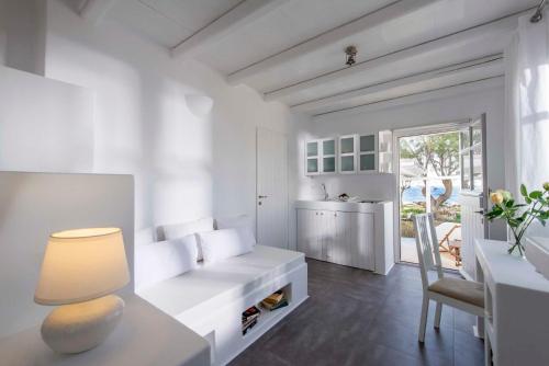 een witte woonkamer met een tafel en een stoel bij Nefeli Sunset Studios in Pollonia