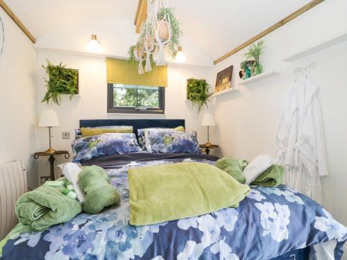 um quarto com uma cama azul e almofadas verdes em High Rigg Shepherd's Sunset em Carlisle