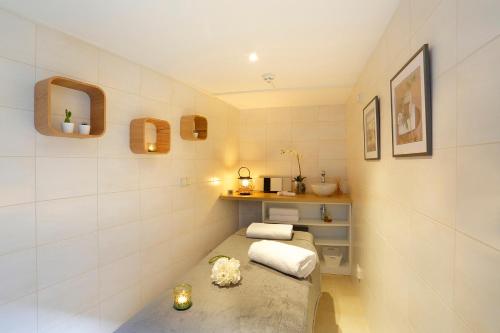 ein kleines Zimmer mit einem Bett und einem Regal in der Unterkunft Hôtel Le Griffon d'Or in Bourg-en-Bresse