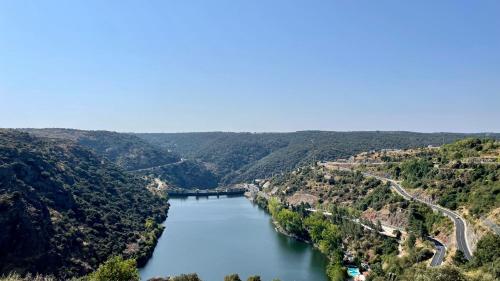 a view of a river with a bridge in the distance at Pensao Vista Bela in Miranda do Douro