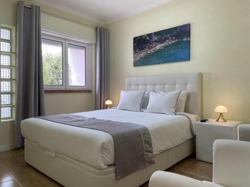 um quarto com uma cama grande e 2 janelas em SK Lisboa Villa Guesthouse em Lisboa