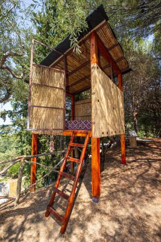 a tree house with a ladder in the middle at Wild Oak Estate - Stunning Views at a Dreamy Location, by ZanteWize in Argasi