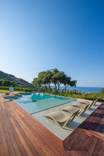a swimming pool with chairs on a wooden deck at Wild Oak Estate - Stunning Views at a Dreamy Location, by ZanteWize in Argasi