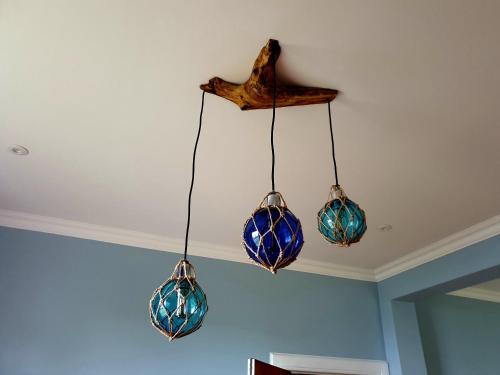 three glass chandeliers hanging from a ceiling at Harbour Lights - Spectacular Sea Views in Crail