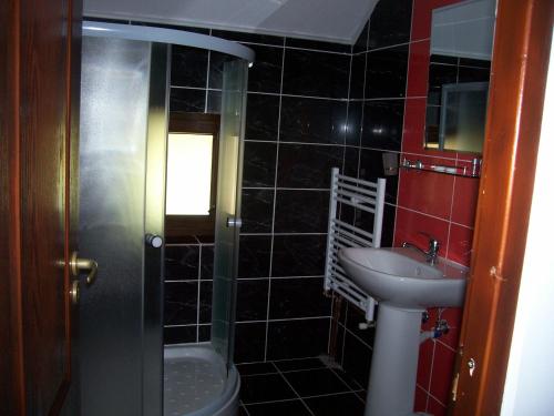 a small bathroom with a sink and a toilet at Pensiunea Mara in Deseşti