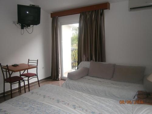 a living room with a couch and a bed and a television at Mijovic Apartments in Budva