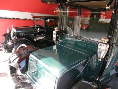 two old cars parked next to a red wall at Tako Baras in Klaipėda
