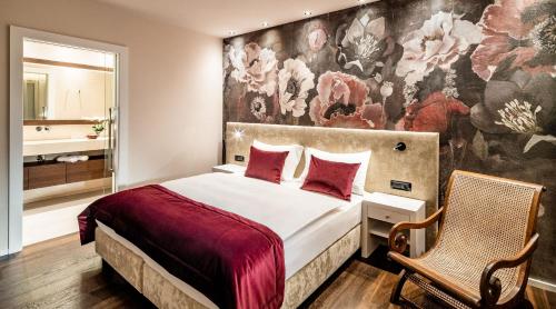 a bedroom with a bed and a wall with flowers at Schenna Chalet - Chalet Penthouse in Schenna